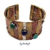Mixed media cuff bracelet with malachite, lapis and turquoise stones set atop textured and antiqued copper, sterling and brass